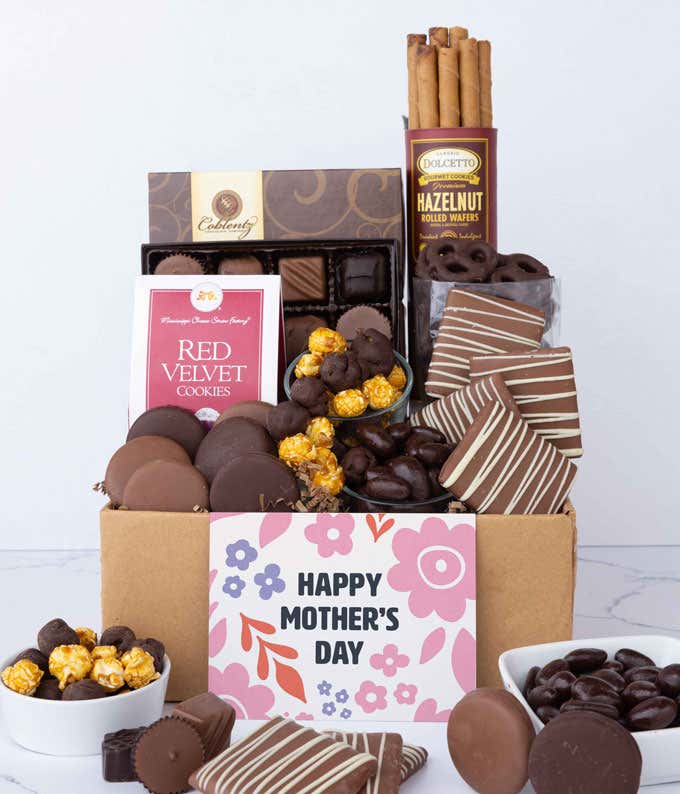A box filled with chocolate-covered pretzels, mini chocolate chip cookies, caramel popcorn, assorted chocolates, mini buckeyes, chocolate covered Oreos, and a Happy Mother's Day card.