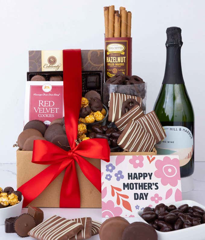 A bottle of Hill & Harbor Sparkling wine sits beside chocolate-covered pretzels, mini chocolate chip cookies, caramel popcorn, assorted chocolates, mini buckeyes, chocolate covered Oreos , and a Happy Mother's Day card.