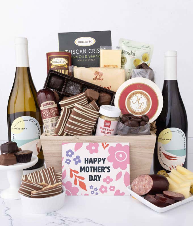 Wooden Mother’s Day gift crate filled with two bottles of Hill & Harbor wine, summer sausage, brie, cheeses, Tuscan crisps, chocolates, pretzels, and gourmet snacks, displayed with a Mother’s Day card.