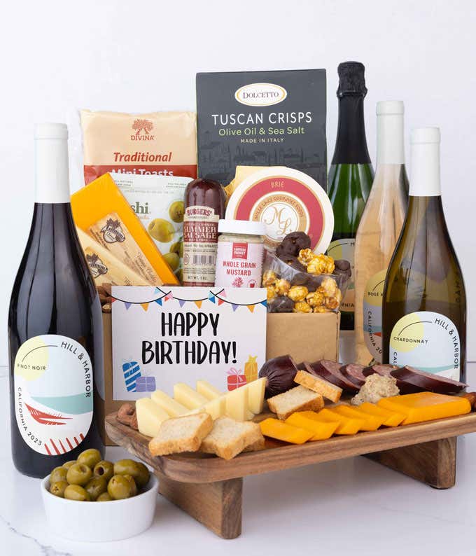 A wine and cheese gift set featuring 4 bottles of California wine - sparkling, rosé, white, and red. Includes a variety of gourmet cheeses, crackers, olives, almonds, summer sausage, and condiments topped with a Happy Birthday Card.